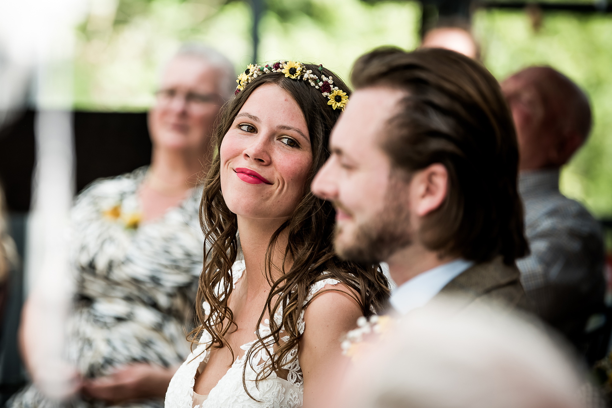 Emotionele momenten bruiloft: bruid kijkt naar bruidegom tijdens ceremonie
