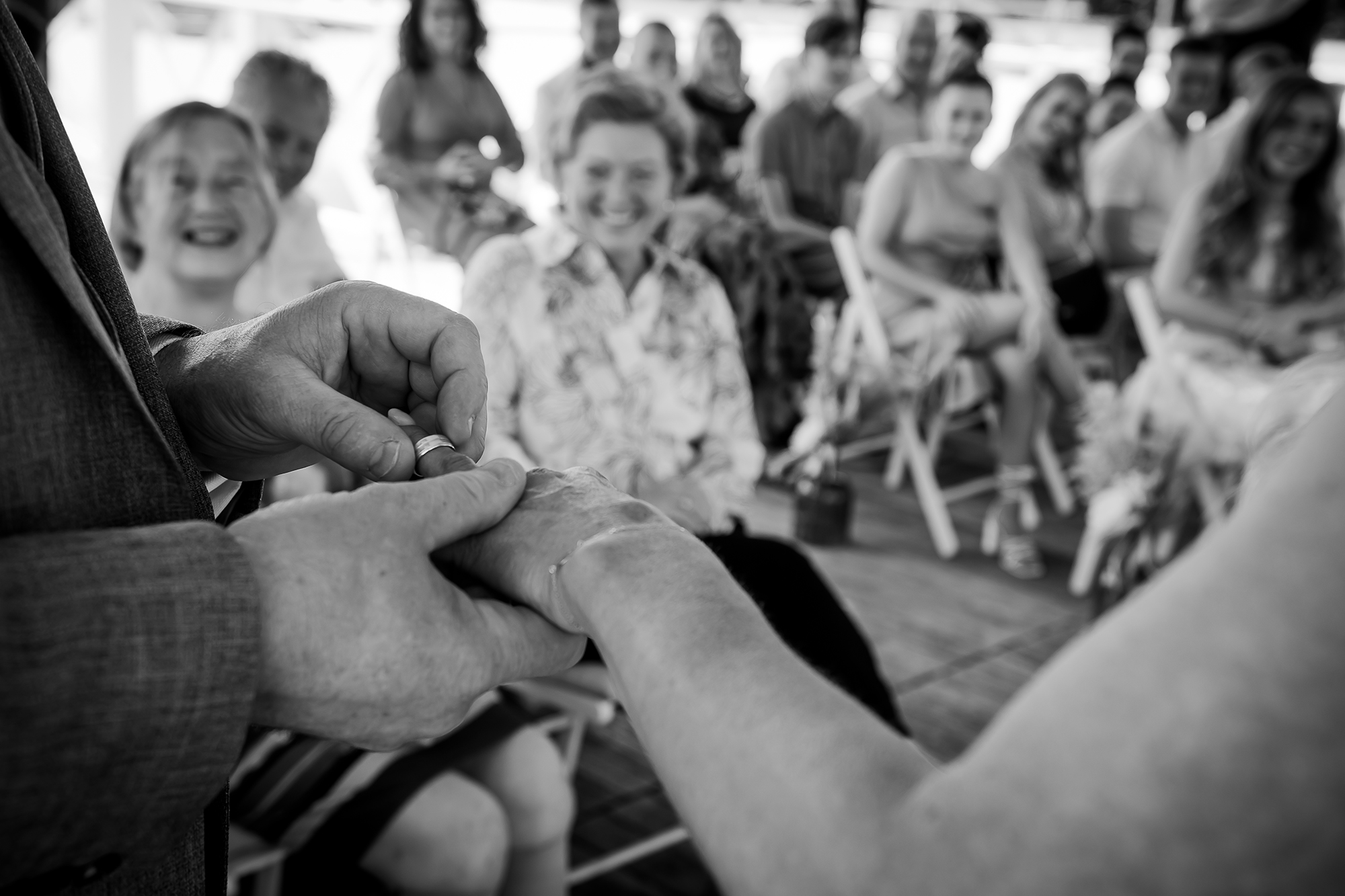 pure trouwfoto: ringen moment met lachende gasten op achtergrond