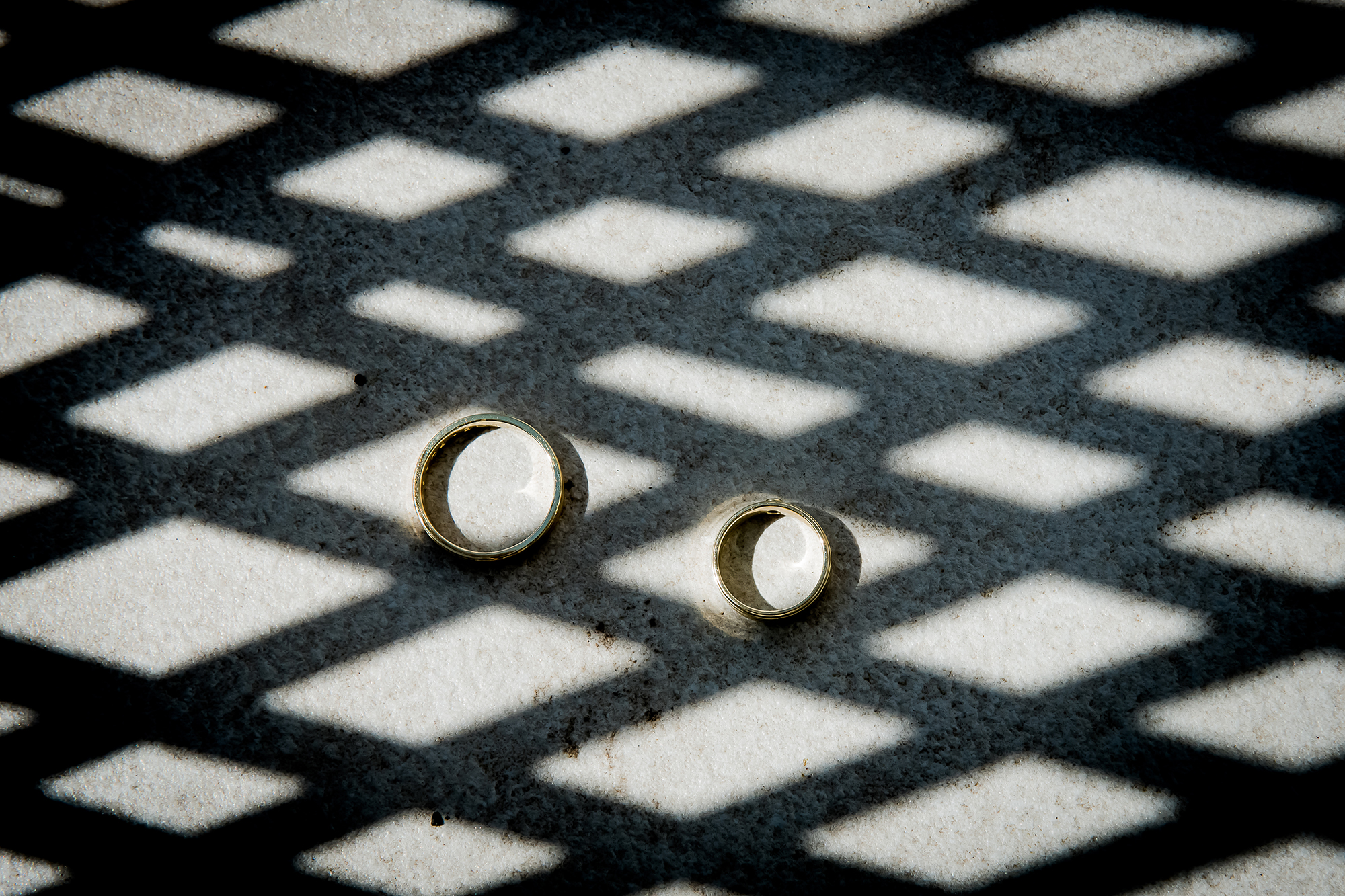 Mooie detais van de trouwdag: trouwringen in een raster van schaduw