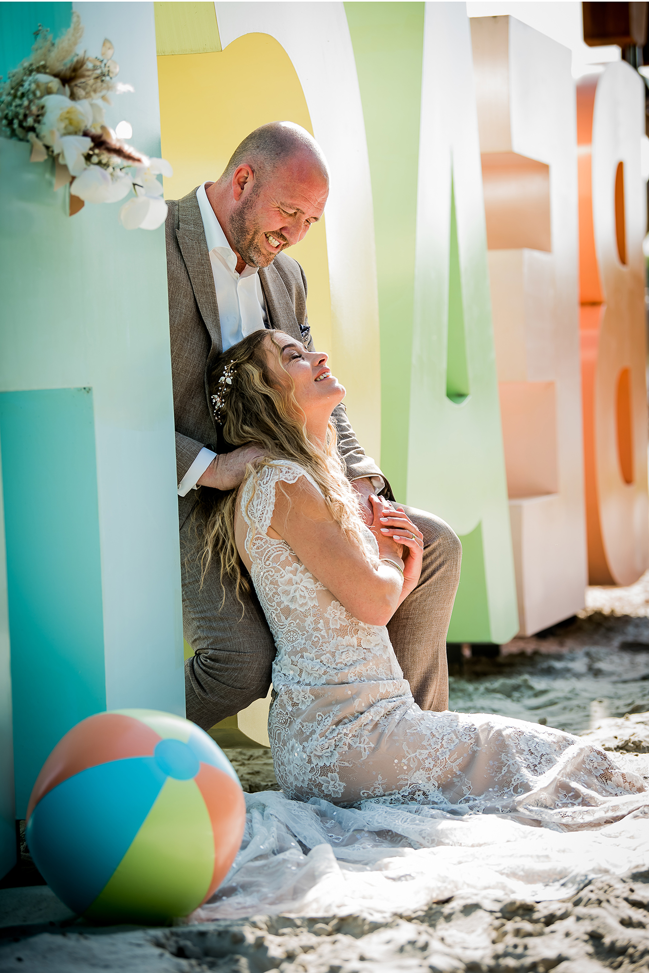 Echt moment trouwfoto: een bruid geniet van zitten in het zand lang het water