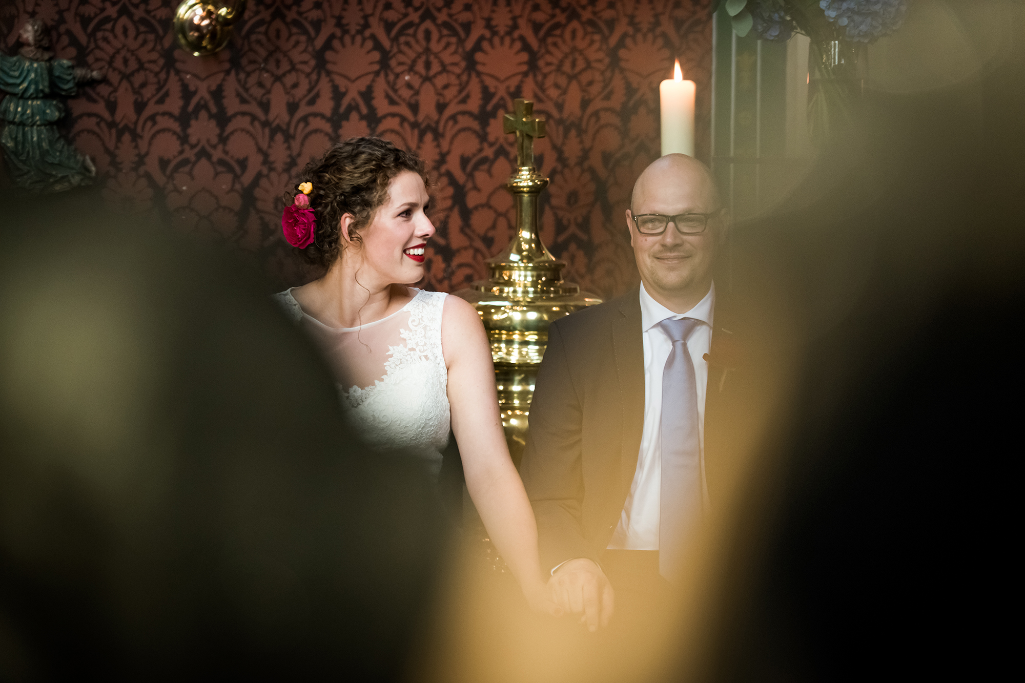 Pure momenten trouwfotograaf: bruid kijkt naar bruidegom tijdens trouwmis