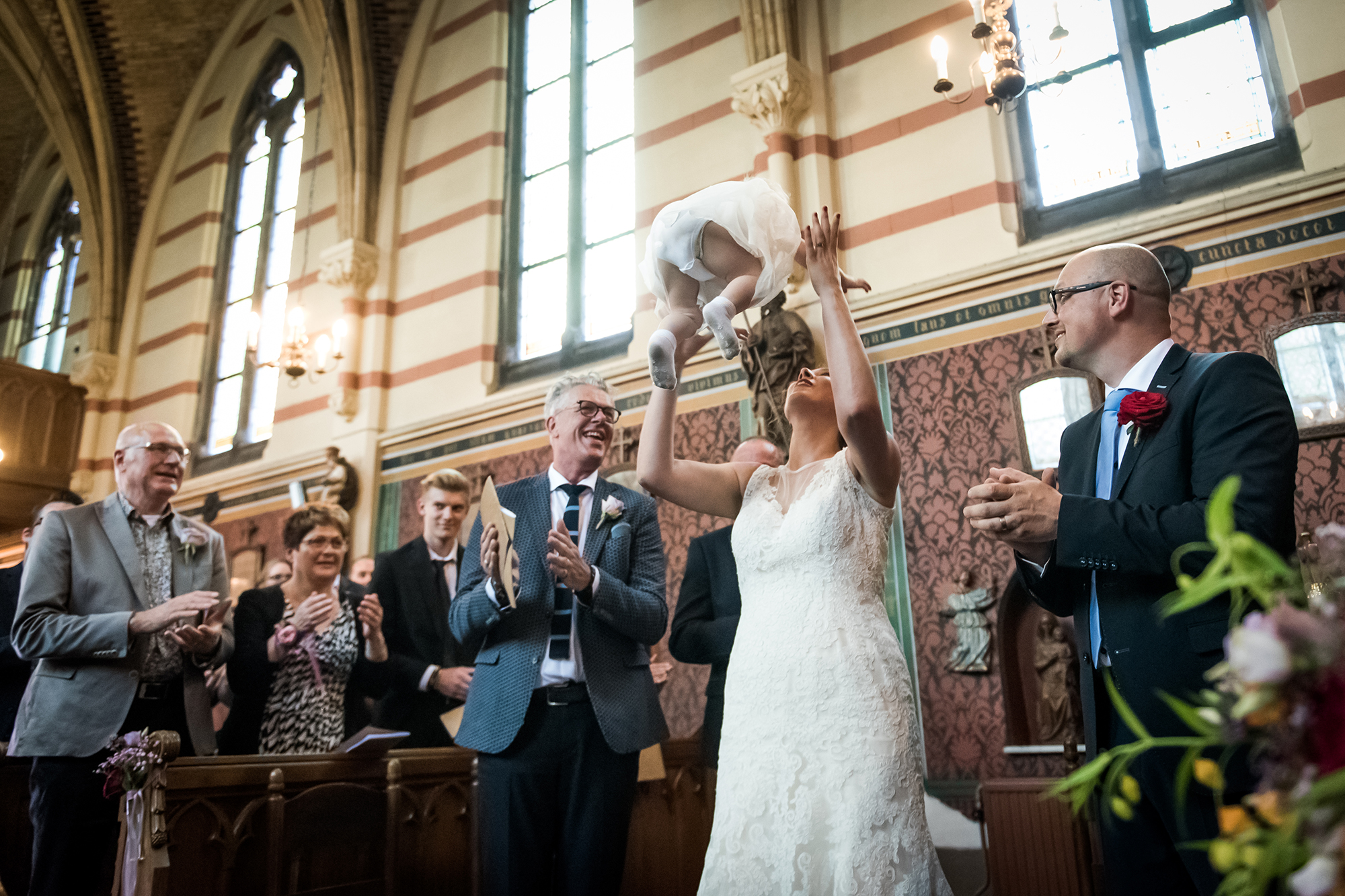 journalistieke bruidsfotograaf Thorn: bruid gooit baby in de lucht in kerk