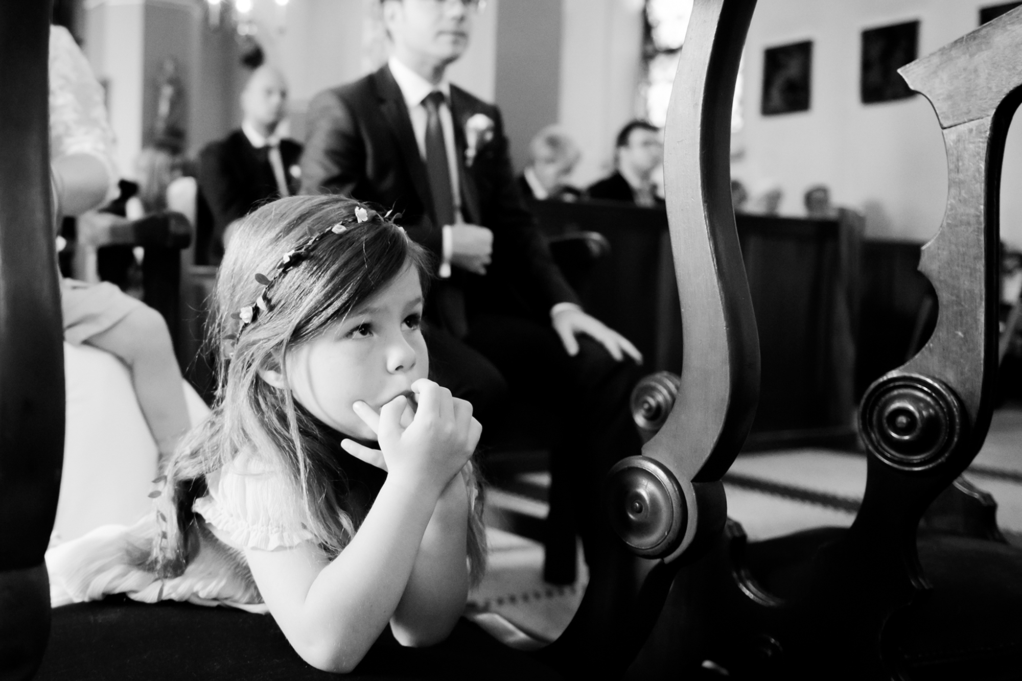 Echte momenten trouwfotografie: meisje knielt tijdens kerkdienst