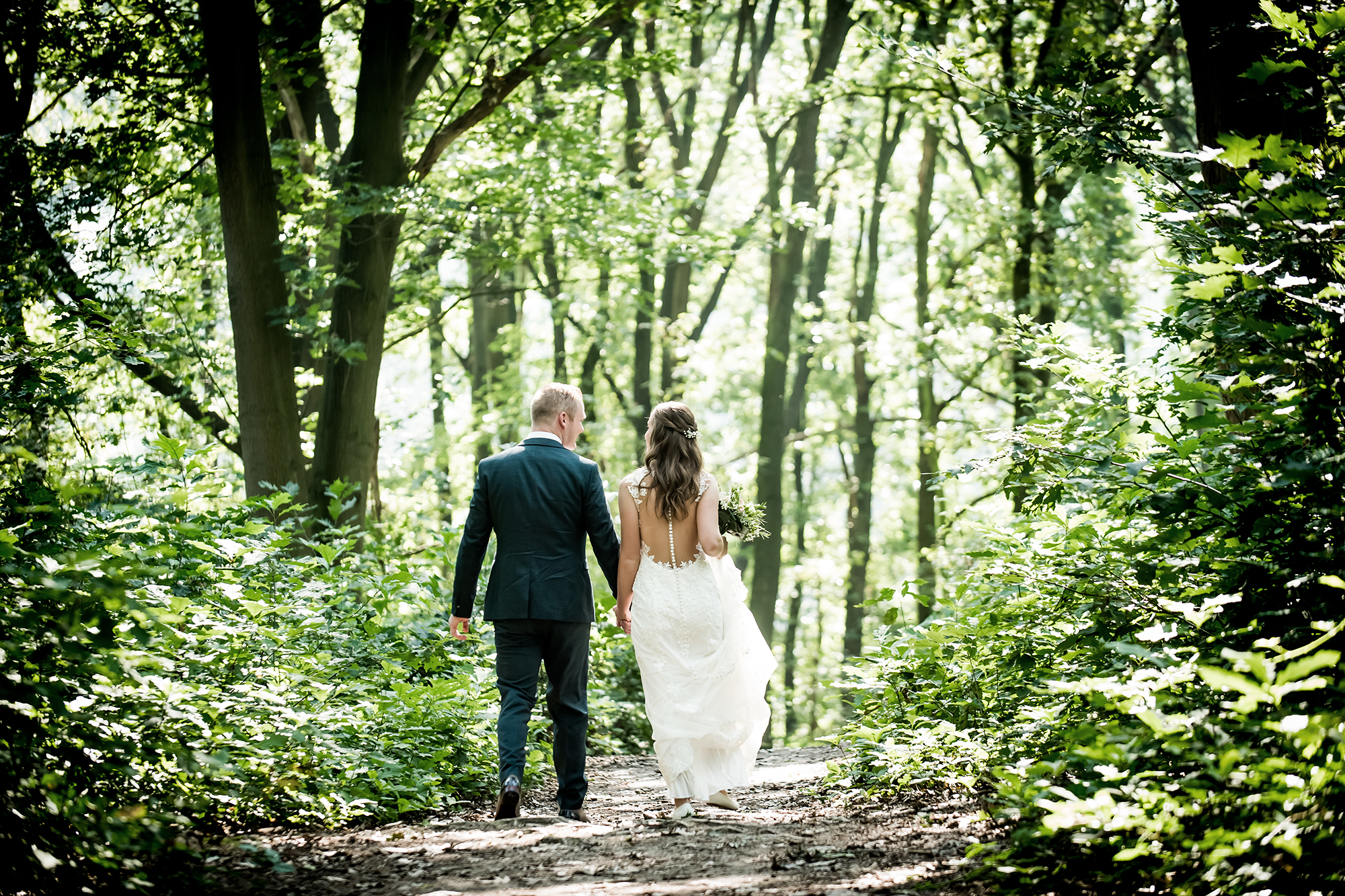 Documentaire bruidsfotografie in Venlo: bruidspaar wandelend door het bos