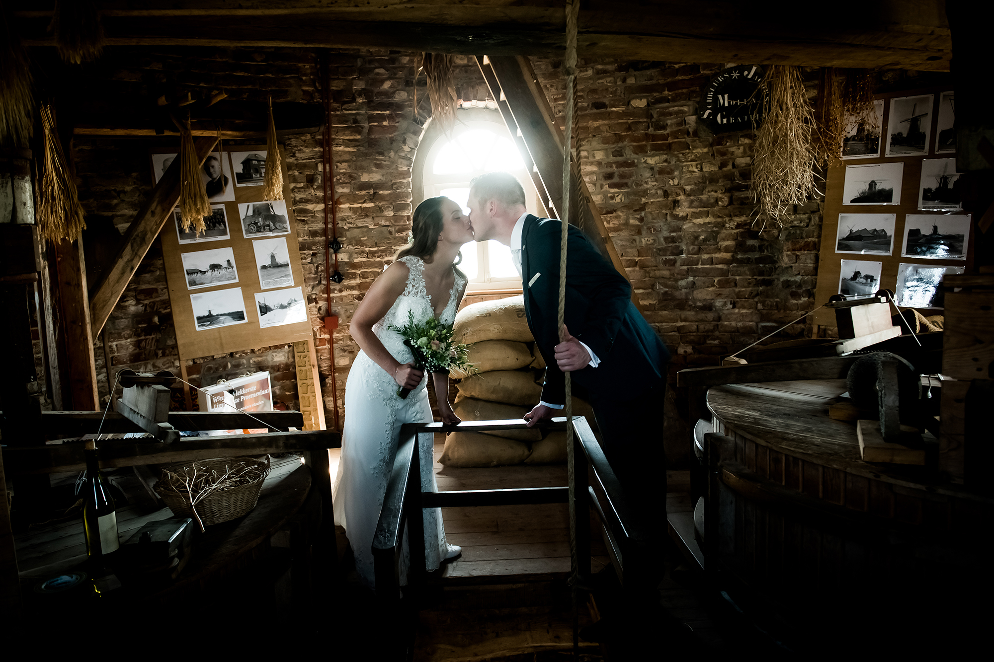 Spontane trouwfotografie: kussend bruidspaar in oude molen