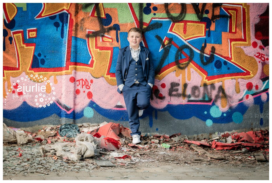 communicantje poseert tegen graffiti muur