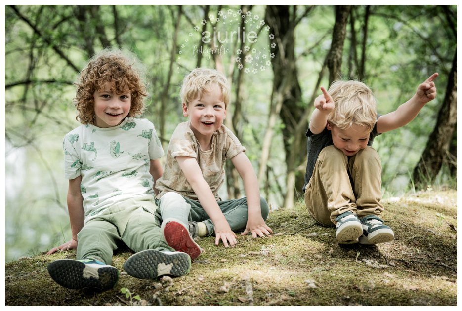 Drie uitgelaten jongetjes en hun moeder tijdens een spontane fotoshoot op de Teverse Heide, spelend in de natuur tussen varens en bomen.