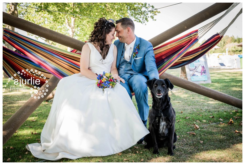 bruidspaar in hangmat met hond erbij