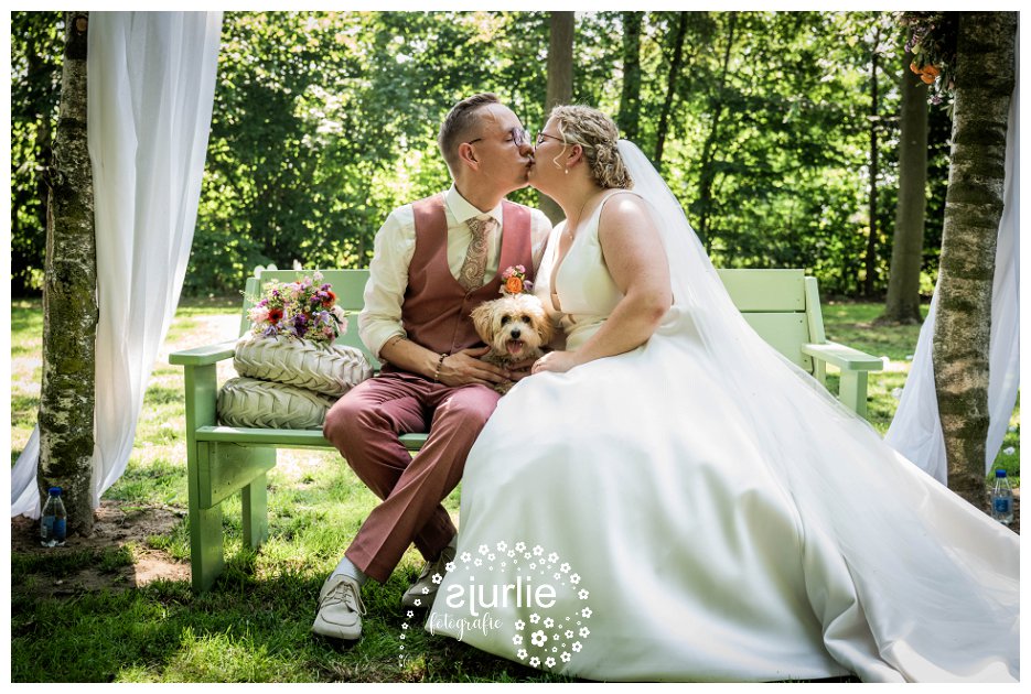 bruidpaar met hondje in tuin