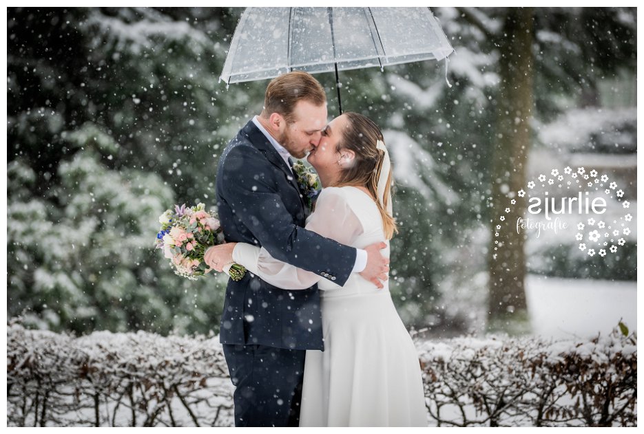 bruidspaar knuffelend in de sneeuw