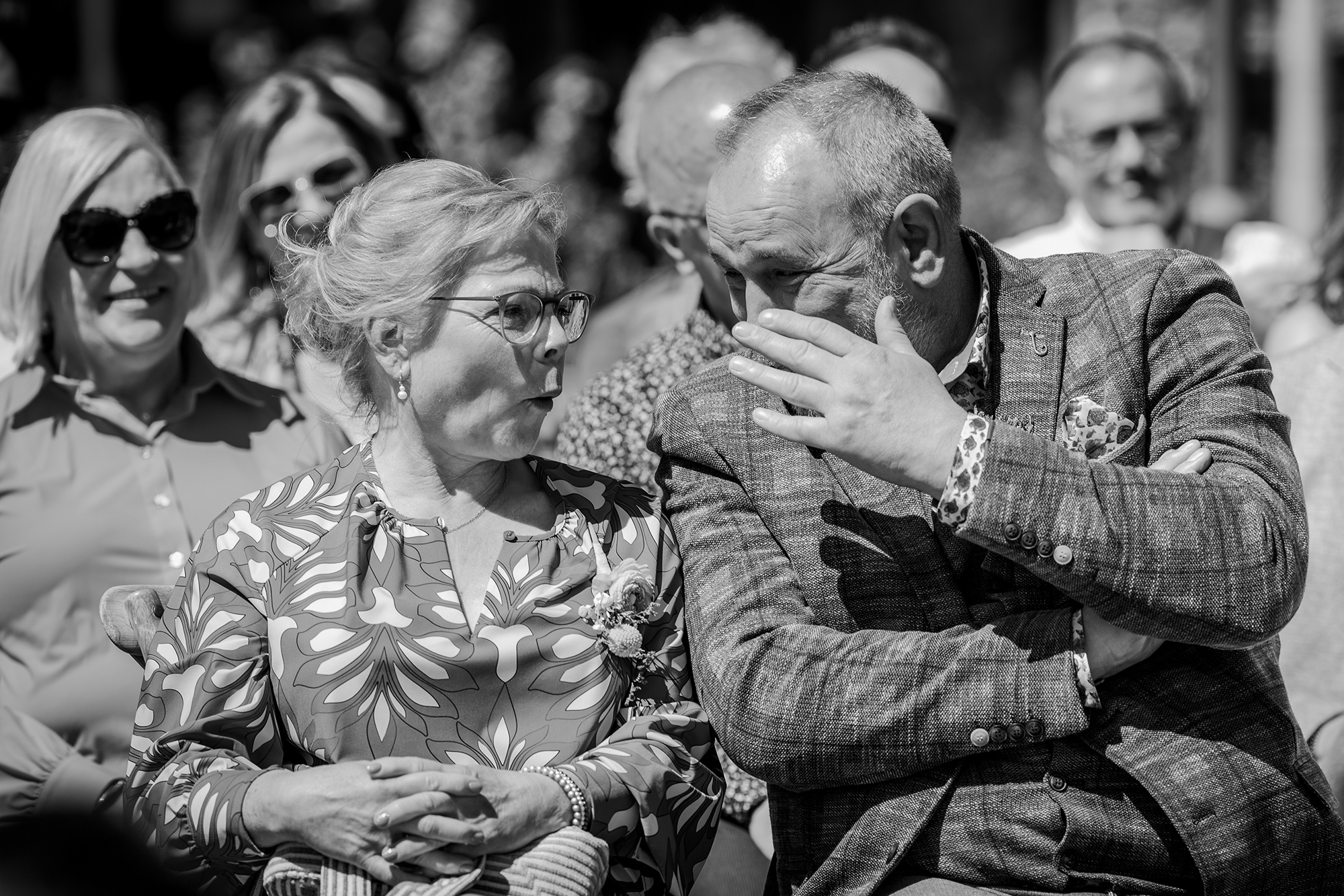 Spontane bruidsfotgraaf Limburg; de ouders van de bruid hebben een onder onsje tijdens de trouwceremonie