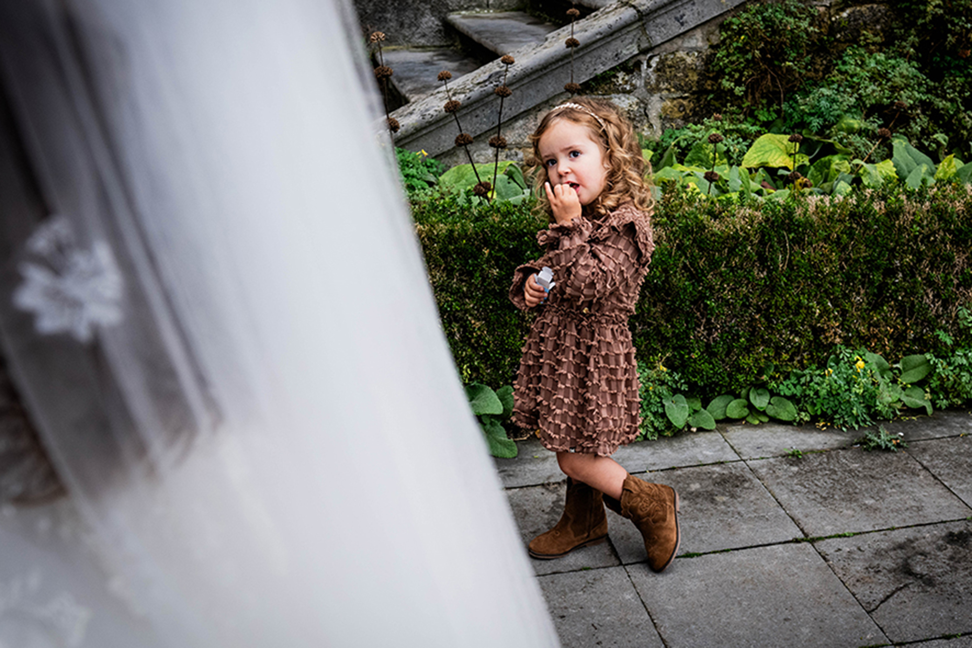 child adores the dress of the bride at chateau Neercanne