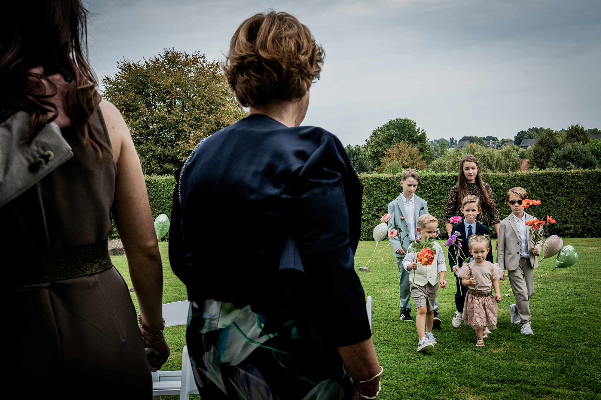 Documentaire trouwfotograaf: Een groepje kinderen wandelt gespannen naar voren bij aanvang van de ceremonie
